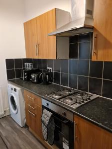 a kitchen with a stove and a washing machine at Shortridge Terrace - 2 in Jesmond