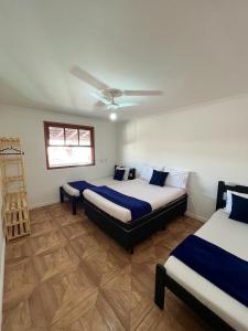 Hostel Passa4 في باسا كواترو: غرفة نوم بسريرين ومروحة سقف