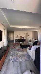 uma sala de estar com um sofá e uma mesa em dockrail and cast anchor drive Apartment em Cidade do Cabo