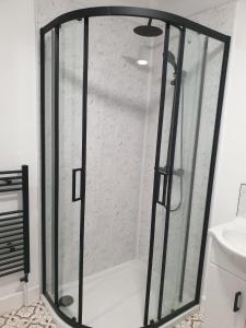 a shower with a glass door in a bathroom at Ty Twt in Wrexham