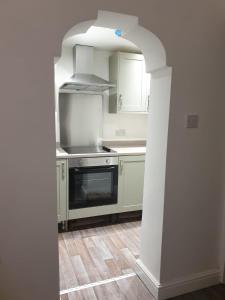 a kitchen with white cabinets and a stove at Ty Twt in Wrexham
