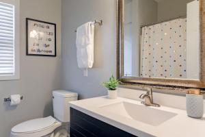 a bathroom with a sink and a toilet and a mirror at UNL Retreat Eclectic 5bd 5mins to Downtown in Lincoln +17 photos