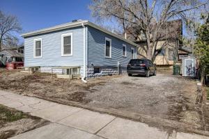a blue house with a car parked in a driveway at UNL Retreat Eclectic 5bd 5mins to Downtown in Lincoln