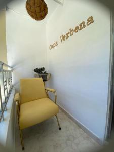 una silla amarilla en una habitación con un cartel en la pared en Casa Verbena, en Cisneros