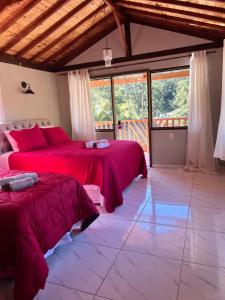 sypialnia z 2 łóżkami i dużym oknem w obiekcie Hospedagem Florenza w mieście Aiuruoca