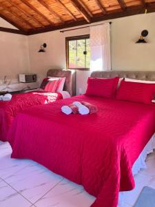 twee bedden in een kamer met een rode deken bij Hospedagem Florenza in Aiuruoca
