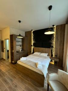 1 dormitorio con 1 cama grande y 1 silla en Talia Apartments, en Belgrado