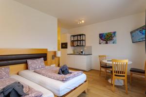 Hart bei GrazにあるFlataid Apartments Marienbrauのベッドルーム1室(ベッド2台、テーブル、椅子付)