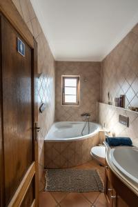 uma casa de banho com uma banheira, um WC e um lavatório. em Aldeia Caiçara Surf House em Sagres