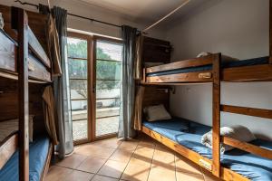a room with bunk beds and a window at Aldeia Caiçara Surf House in Sagres