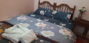 a bed with a blue comforter with flowers on it at A 5 minutos del aeropuerto de fes in Oulad Tayeb