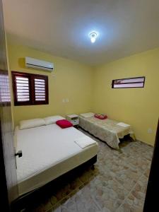 a bedroom with two beds and two windows at Casa de praia Amarópolis in Paripueira