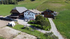 an aerial view of a farm with a barn and a house at Ladinser Hof Kuschelecke in Castelrotto