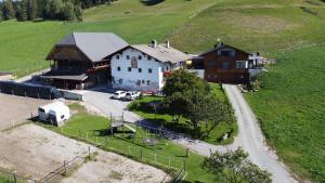una vista aerea di una fattoria con un fienile e una casa di Ladinser Hof Kuschelecke a Castelrotto