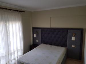a bedroom with a bed and a large window at Kriopigi Apartments 2 in Kriopigi