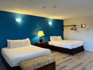 Habitación de hotel con 2 camas y pared azul en VIP Motel, en Parksville
