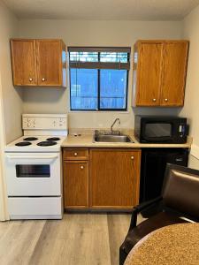 una cucina con piano cottura bianco e lavandino di VIP Motel a Parksville