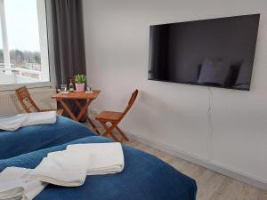a room with two beds and a flat screen tv on the wall at BurgK59, 3 BR, 6 Beds, TV, Kitchen and Bath in Muldenstein