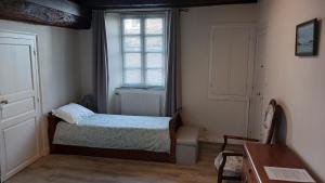 - une petite chambre avec un lit et une fenêtre dans l'établissement Le Logis de Stofflet, à Maulévrier
