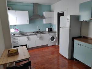 a kitchen with a white refrigerator and a table at Habitación doble ALAMEDA CENTRO MACARENA in Seville
