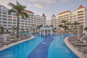 a resort pool with chairs and a gazebo at Bahia Principe Luxury Runaway Bay - Adults Only All Inclusive in Runaway Bay