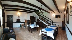 a dining room with tables and chairs and a staircase at Pensiunea Irina in Botuş