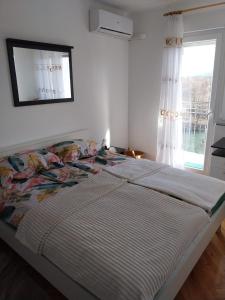 uma cama grande num quarto com uma janela em River View Apartment Gospic em Gospić