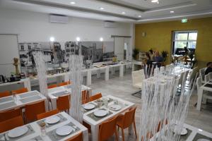 una sala da pranzo con tavoli e sedie bianchi e persone di Hotel D'Elegant Dubrovnik a Dubrovnik Altre 28 foto