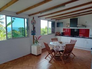 una cucina e una sala da pranzo con tavolo e sedie di Rosekayen a Capesterre-Belle-Eau