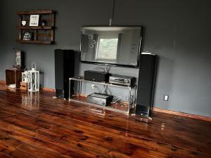 a living room with a tv and speakers and a wooden floor at Studio na Miarę in Jarocin