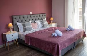 a bedroom with a bed with two stuffed animals on it at Nikitas Apartments & Suites in Kanali