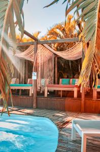 a resort with a swimming pool and a hammock and benches at Tropicana Suites in Deshaies