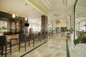 een restaurant met een bar en tafels en stoelen bij Bahia Principe Luxury Runaway Bay - Adults Only All Inclusive in Runaway Bay