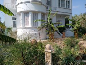 una casa bianca con un giardino di fronte di Tower traditional pool villa a Kremasti