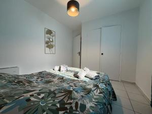 a bedroom with a bed with a floral bedspread at Spacieux appartement ~ Halles ~ Wifi ~ Centre in Narbonne