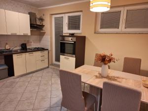 a kitchen with a table with chairs and a dining room at Studio Apartman Luna in Zadar