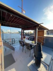 a deck with a table and chairs on a boat at Houseboat-Amsterdam-Classic in Amsterdam