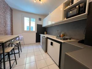 a kitchen with a sink and a table in it at Spacieux appartement ~ Halles ~ Wifi ~ Centre in Narbonne