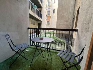 a balcony with a table and chairs on a balcony at Spacieux appartement ~ Halles ~ Wifi ~ Centre in Narbonne