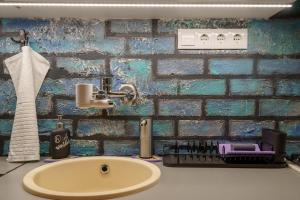 a bathroom with a sink and a brick wall at Bárka Home in downtown Buda in Budapest +76 photos