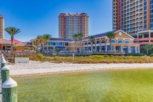 un edificio sulla spiaggia con palme e edifici di Exquisite Island Condo Resort Perks and Views! a Pensacola Beach