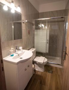 a bathroom with a sink and a toilet and a shower at Nikitas Apartments & Suites in Kanali