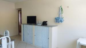 um quarto com um armário azul com uma televisão em Condomínio Caribe Fortaleza CE em Caucaia
