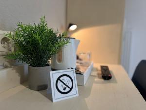 una señal de no fumar en un mostrador junto a una maceta en Hotel Pelikan en Kitzingen
