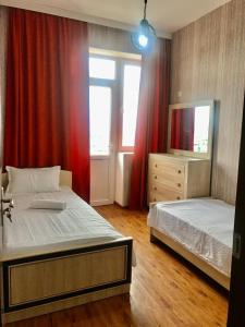a bedroom with two beds and red curtains at Best choice in Kutaisi