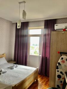 a bedroom with a bed and a window with purple curtains at Best choice in Kutaisi