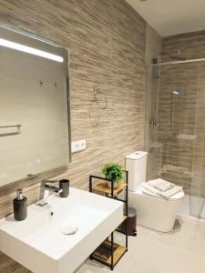ein Badezimmer mit einem Waschbecken, einem WC und einem Spiegel in der Unterkunft Apartamento entero en Valencia in Valencia