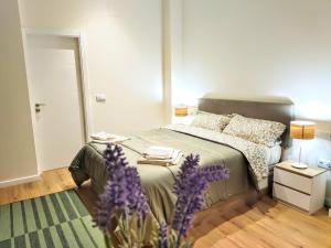 ein Schlafzimmer mit einem Bett und einer Vase aus lila Blumen in der Unterkunft Apartamento entero en Valencia in Valencia
