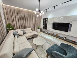sala de estar con sofá y TV en Villa Meminaj, en Vlorë