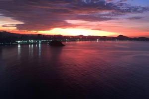 um pôr-do-sol sobre uma grande massa de água em Apartamento com Vista Única e Maravilhosa !!! em São Vicente